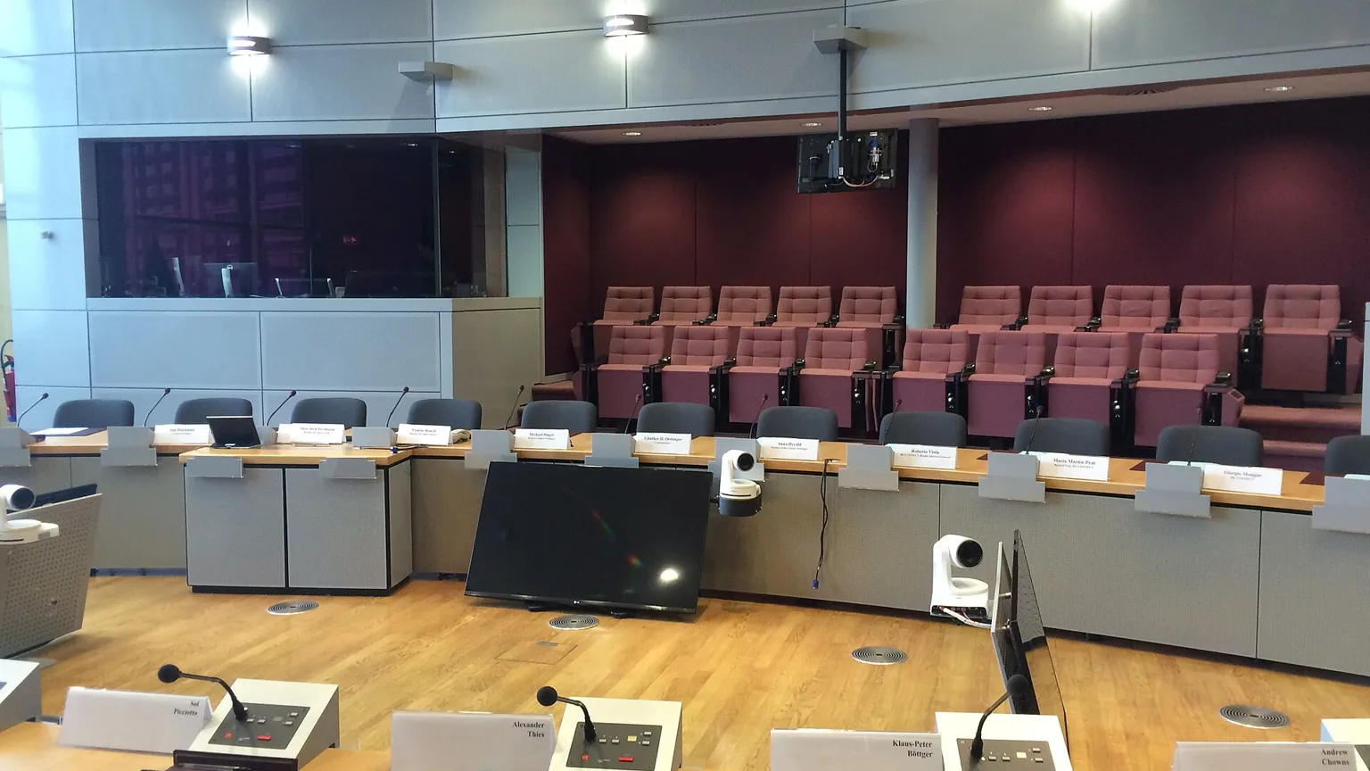 AI illustration: Empty conference room with rows of desks and microphones