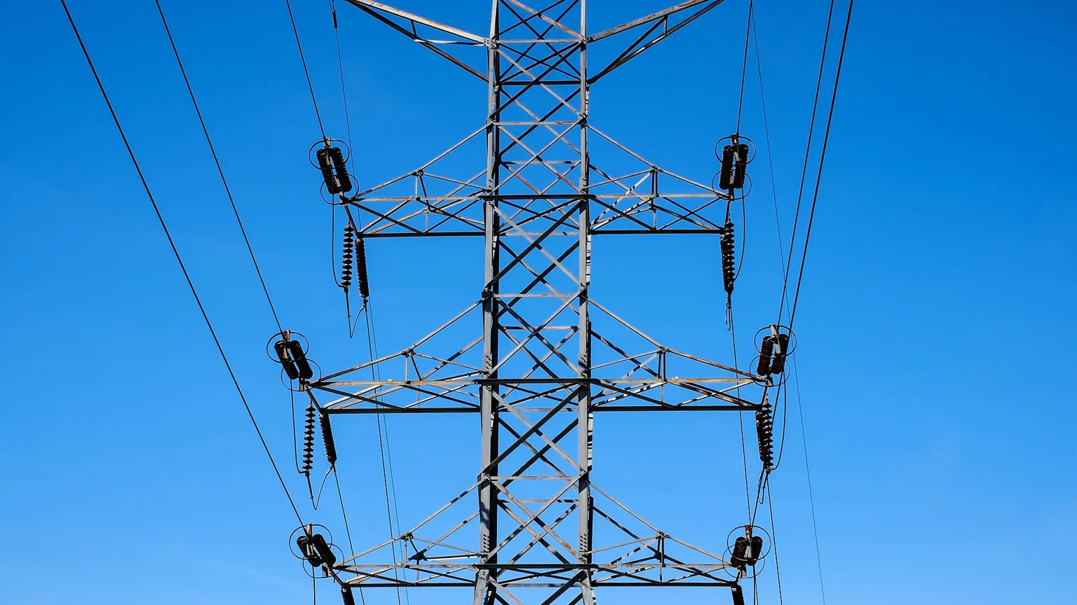 Electricity transmission towers against a blue sky