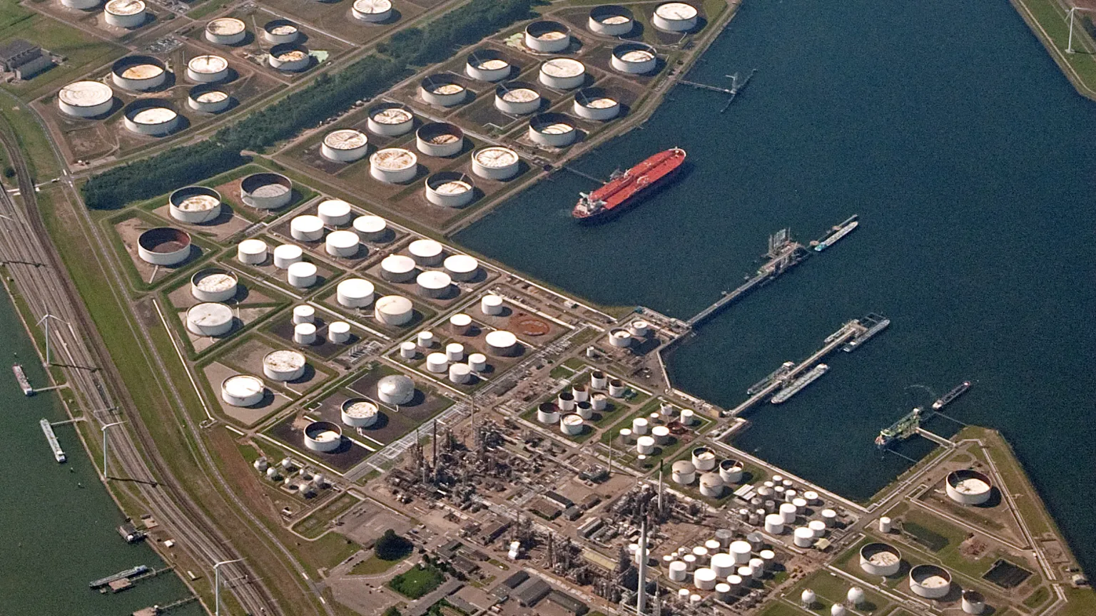 A diesel tanker truck at a European refinery terminal with storage tanks