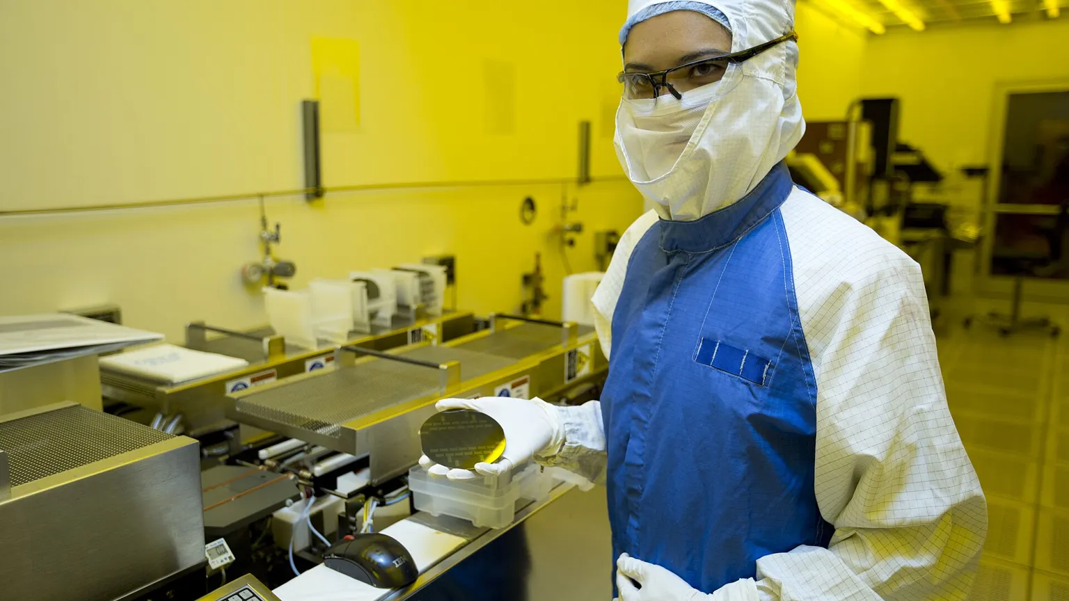 A silicon wafer and a stack of memory chips on a clean-room bench